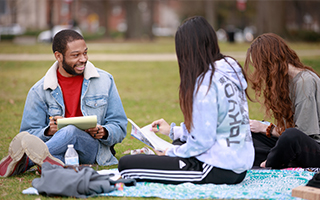 three students studying on the Quad
