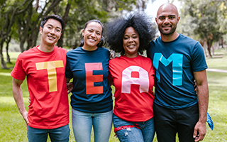 4 people wearing shirts that spell out the word team